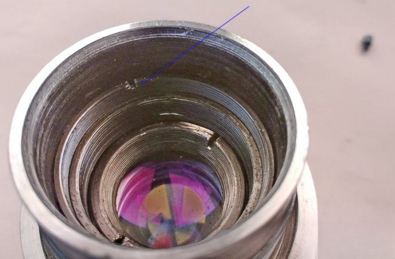 Unscrewing lens retainer ring with spanner tool