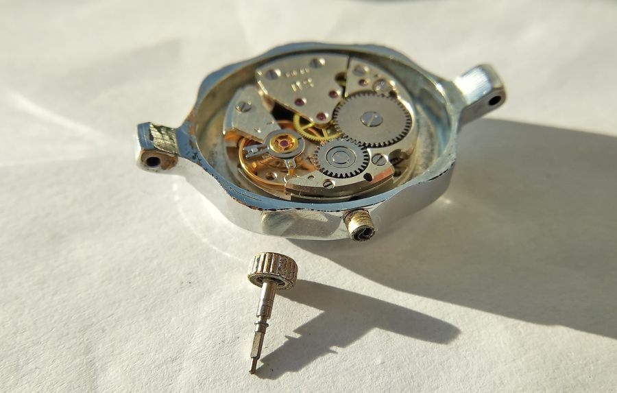 Winding stem and crown withdrawn and lying in front of the case