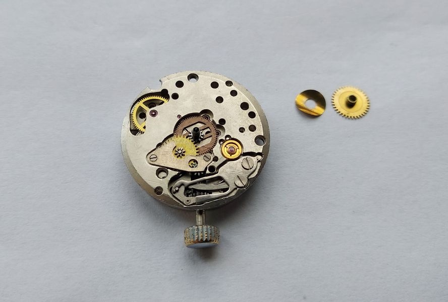 Hour wheel and its curved spring washer placed next to the movement