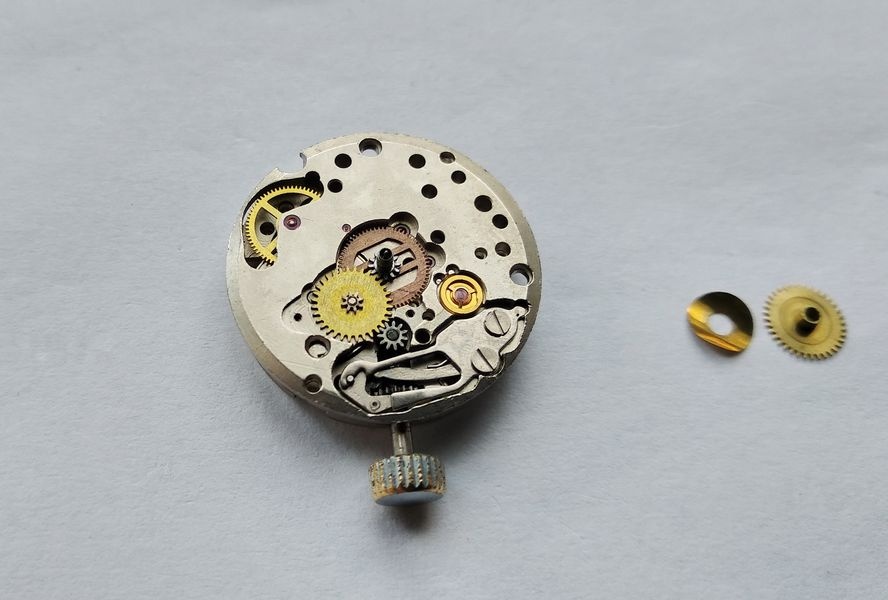 Exposed motion works of the Luch 1809, with the copper-colored spring wheel on the cannon pinion