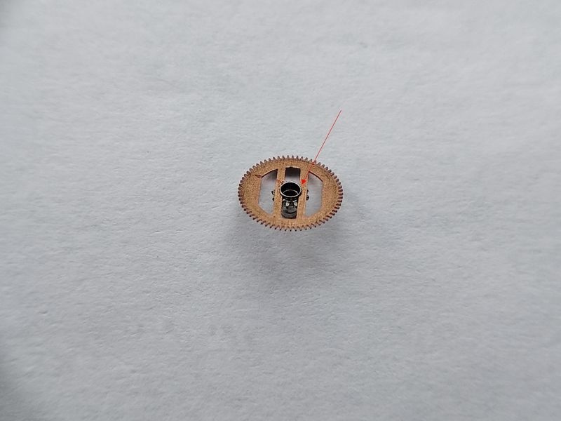 Close view of the arched spring wheel on the Luch 1809 cannon pinion, with a red line marking a spring arm