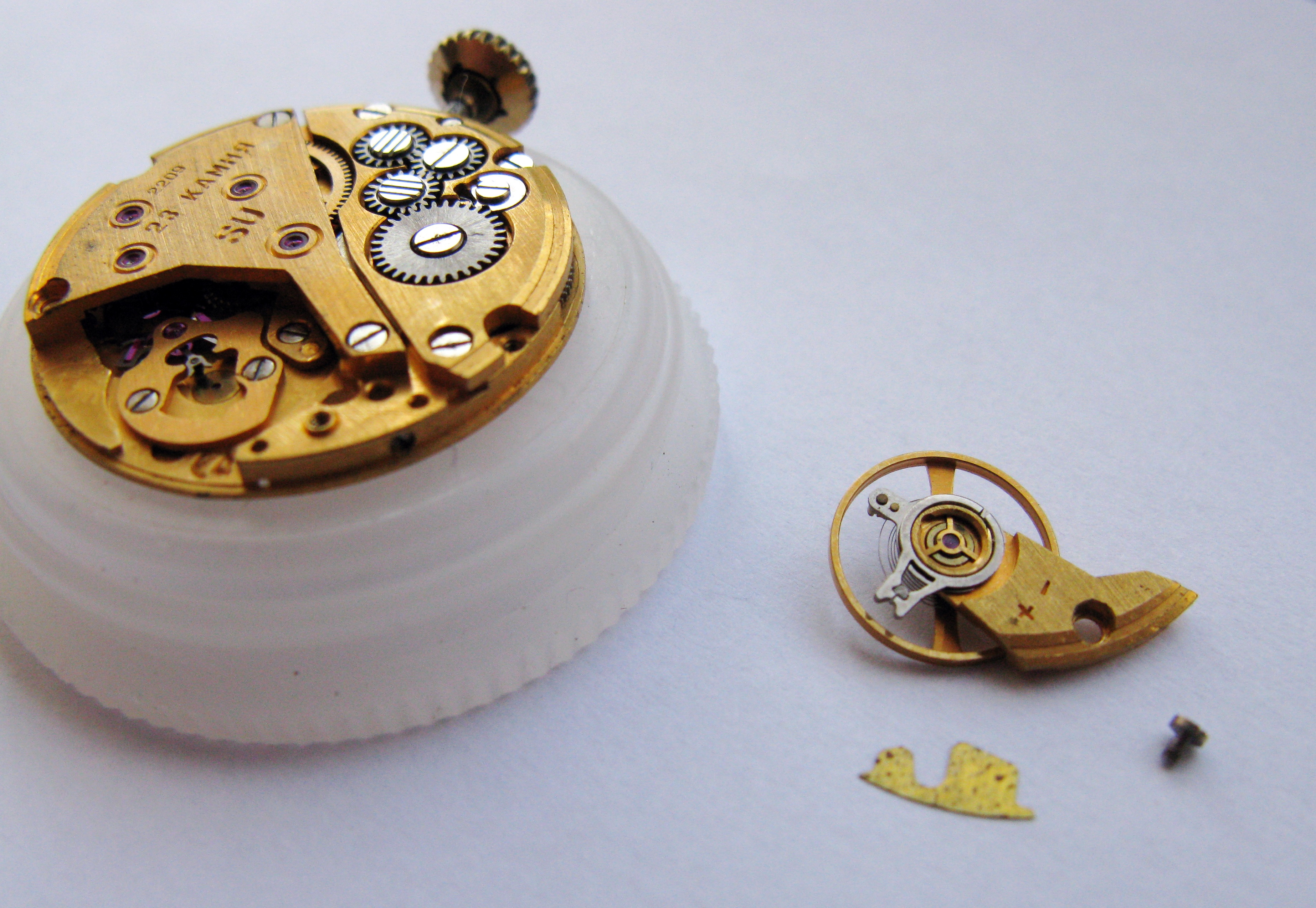 Balance assembly lifted clear of the movement and placed to one side with its stud screw.