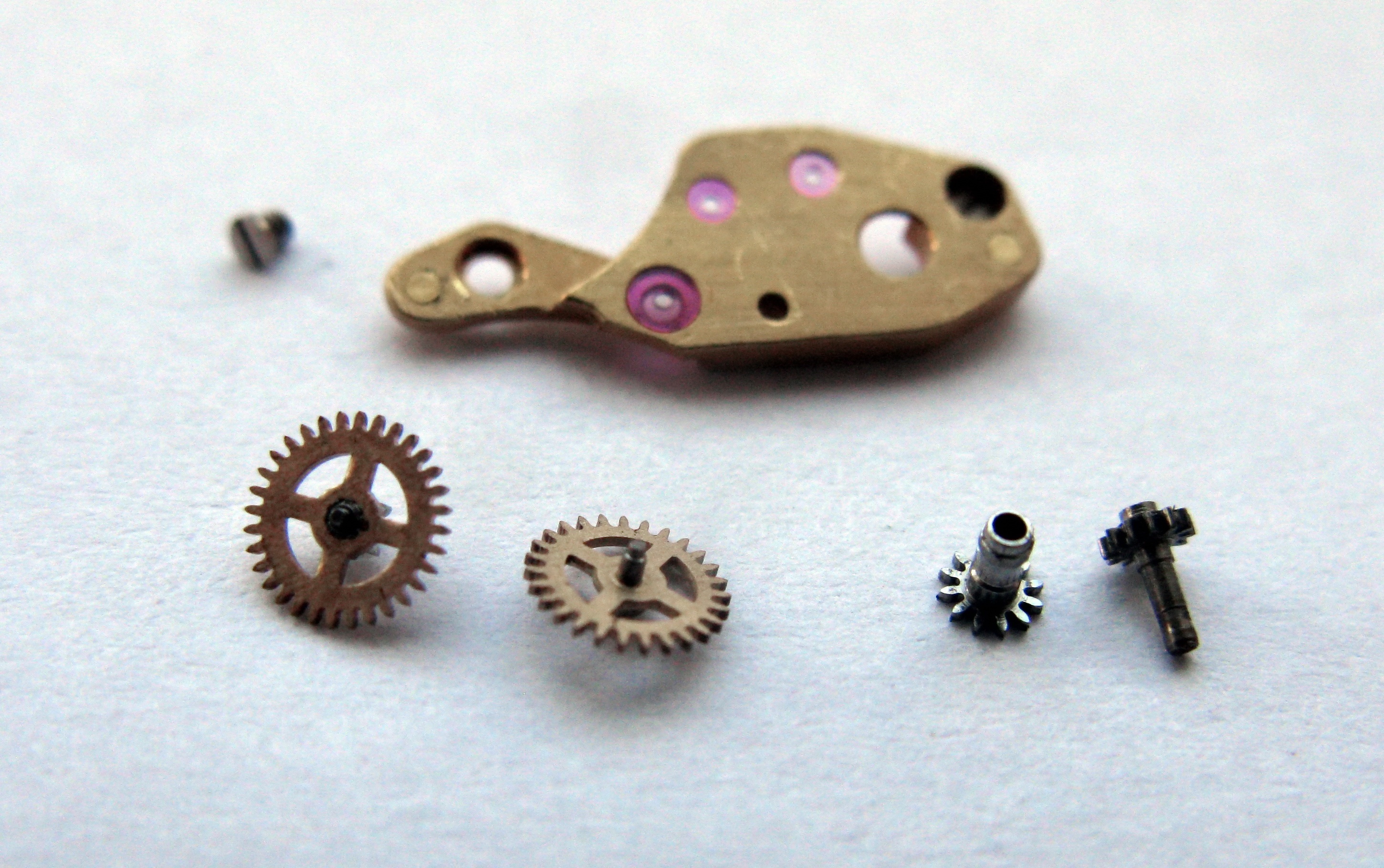 The central-wheels bridge on paper with the two split center wheels, the central pinion and a screw.