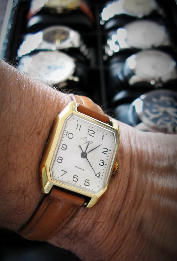The serviced Luch on the wrist over an open watch box, on a tan leather strap.
