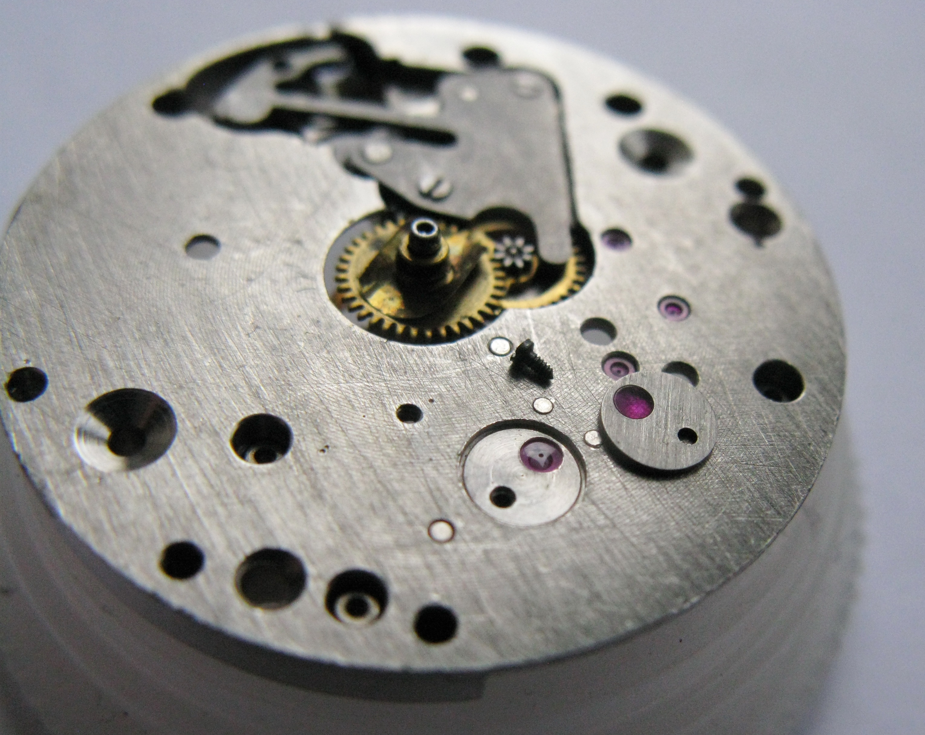 The balance cap jewel being removed from the mainplate.