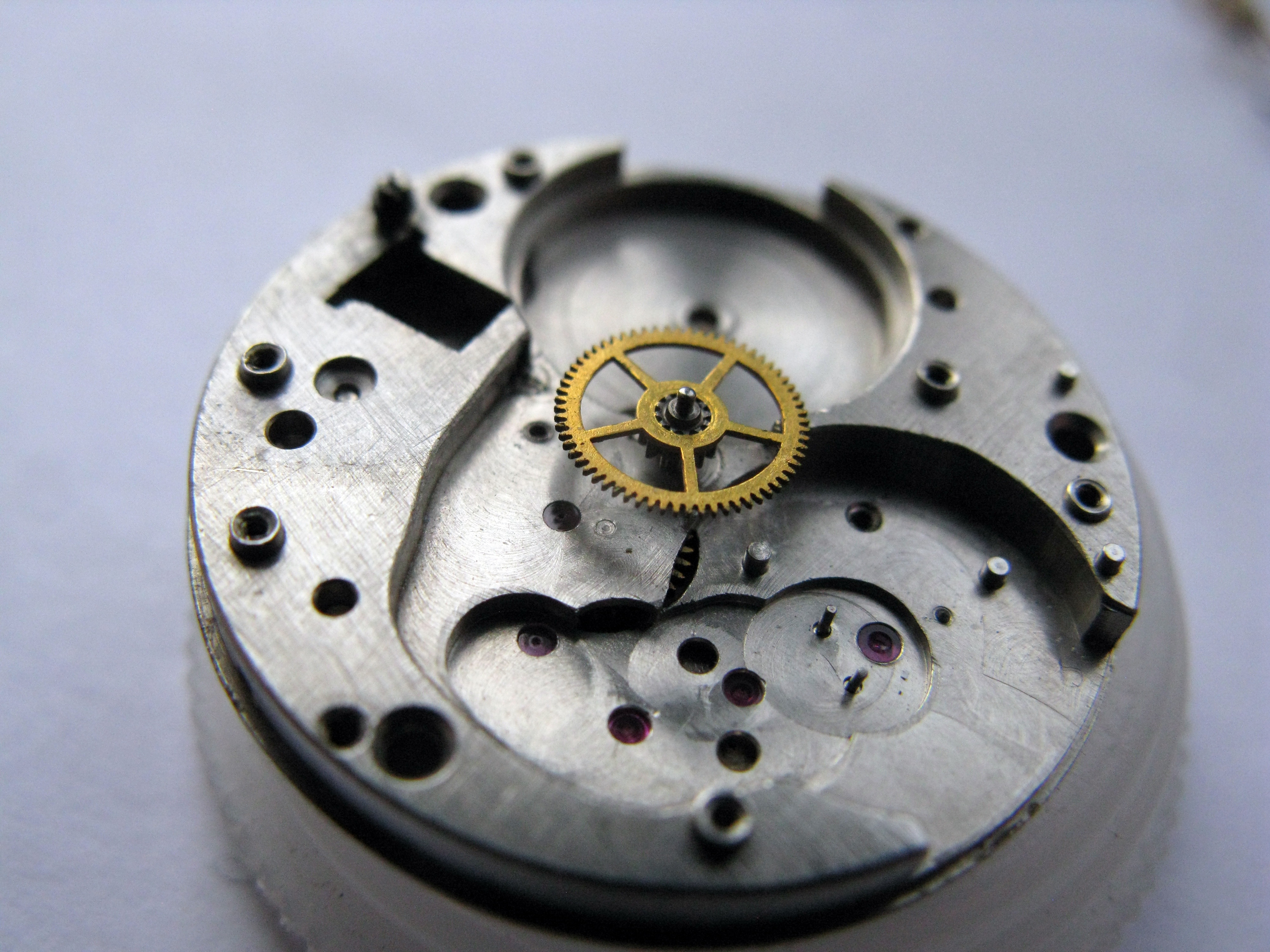 The center wheel still in place on the plate before crossing to the dial side.