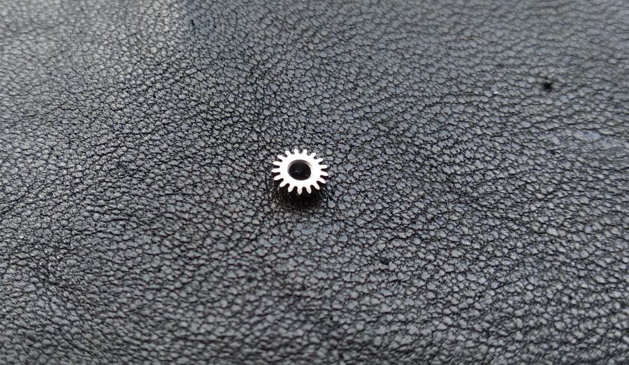 The reverse side of the winding pinion, a smooth flat face with no teeth