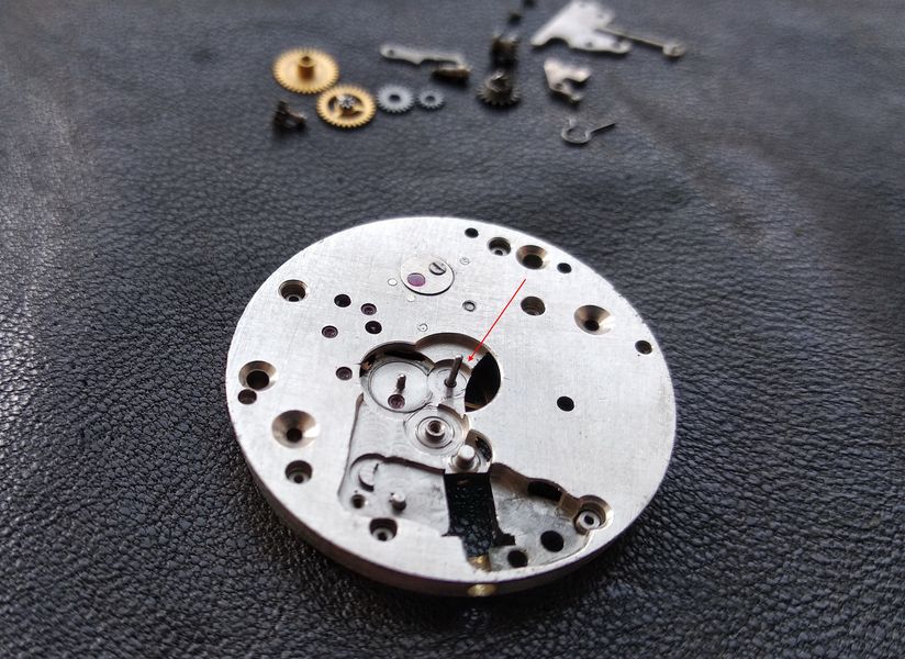 The bare center-wheel arbor standing proud of the plate, the seat for the friction-fitted cannon pinion