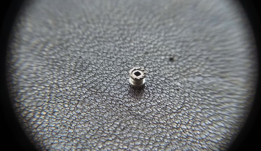 The castle viewed to show its ratchet teeth and the square through-hole that fits the stem's square section