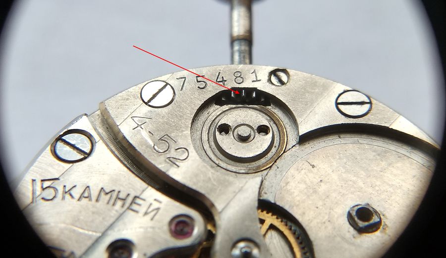 The barrel bridge installed, a red arrow marking the recess that clears the winding-pinion rim beside the crown wheel