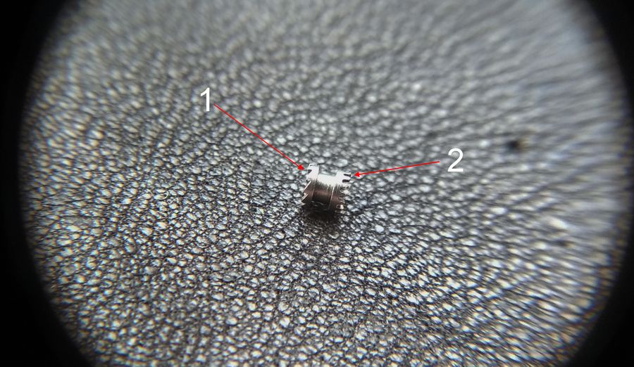 The castle clutch piece with its ratchet ring and crown rim numbered and a central waist groove visible