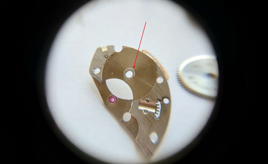 Close view of the barrel bridge showing a tall boss for the barrel arbor and a jewel under the center-wheel heel, with no visible wear