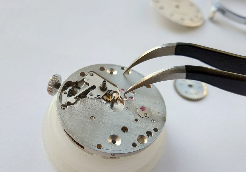 Pulling the friction-fitted cannon pinion off the center-wheel arbor on the dial side