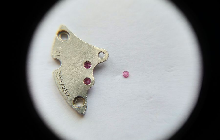Pushing a jewel out of a bent donor bridge with a flat-ended wooden pusher on a staking block