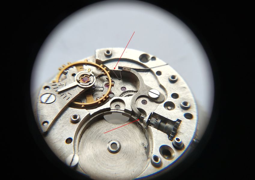 Detail showing the spring finger held clear of the balance wheel so the balance can oscillate freely