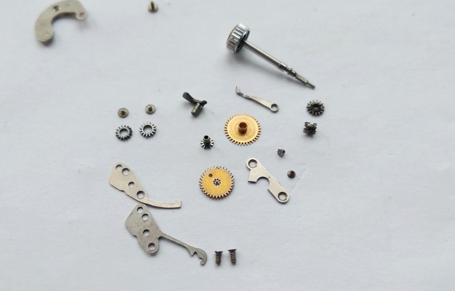 The removed keyless-works components arranged on the bench