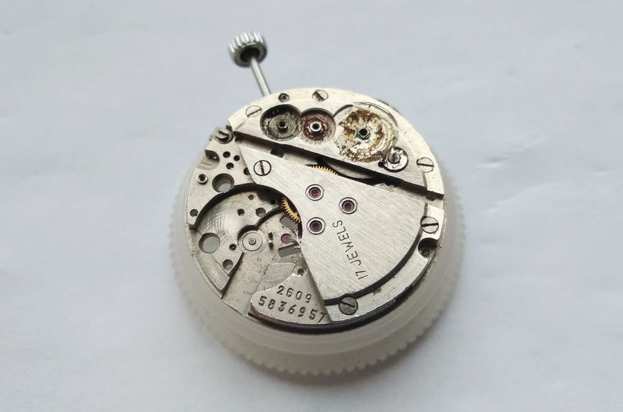 The area beneath the winding wheels showing the same dried, darkened lubricant