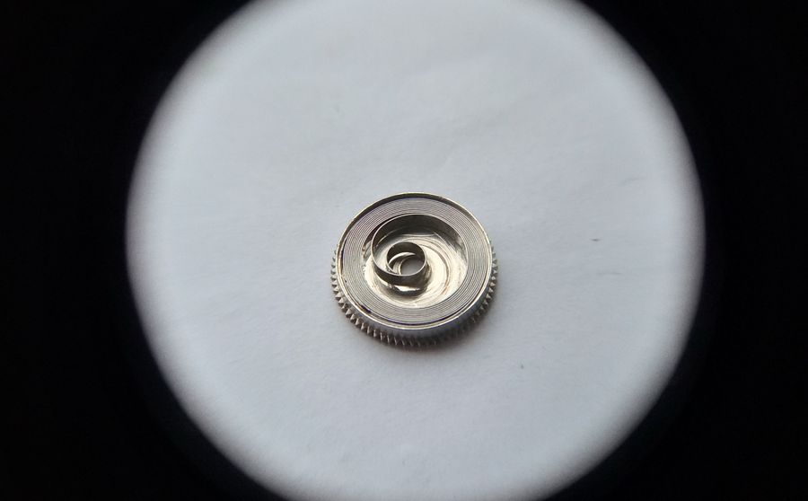 The mainspring being seated back into the barrel