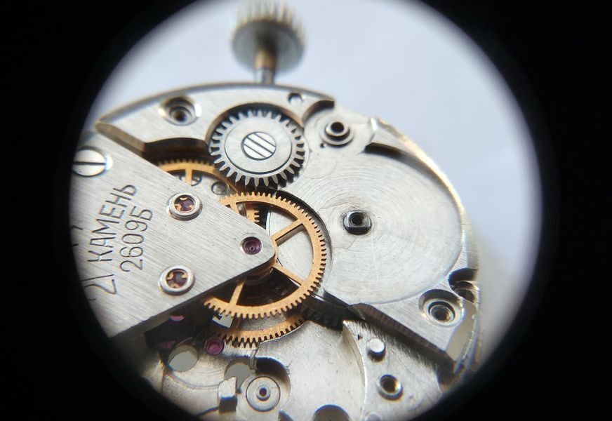 Replacement barrel bridge installed on the Raketa 2609B movement with the three screws correctly positioned — two short at standard posts, the long screw at the click post