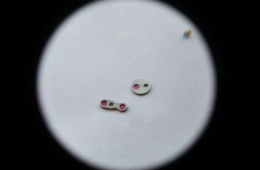Correct oil drop applied to an overlay jewel from the Raketa 2609B gear train bridge, showing the precise quantity required for correct capillary retention