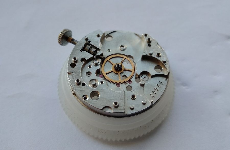 Center wheel of the Raketa 2609B reinstalled in the main plate jewel with the cannon pinion arbor extending correctly through the dial side of the plate
