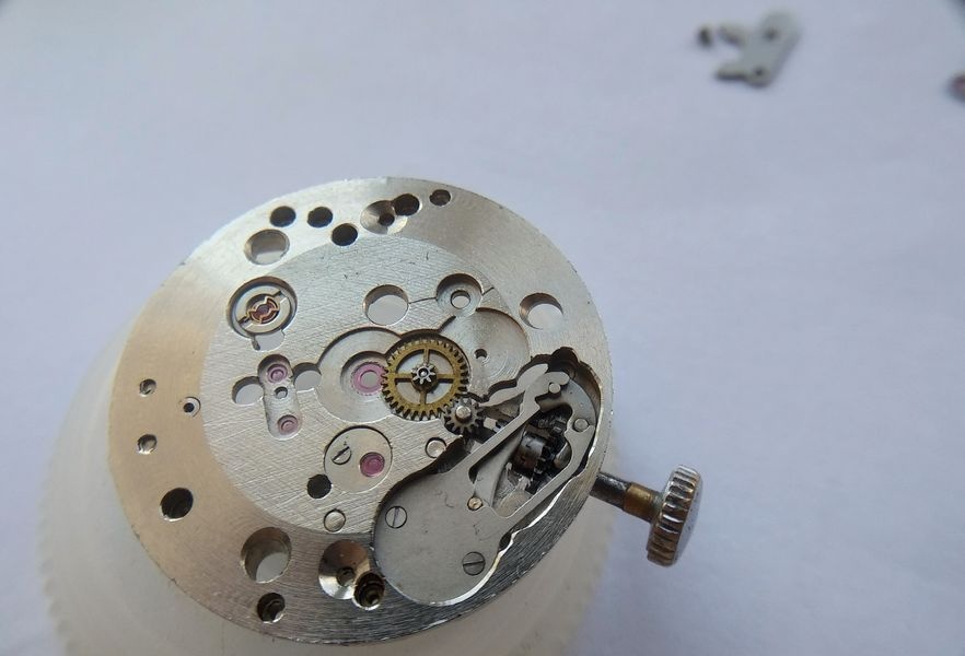 Overlay jewels on the dial-side pivot positions of the Raketa 2609B being removed along with the setting and clutch lever bridge