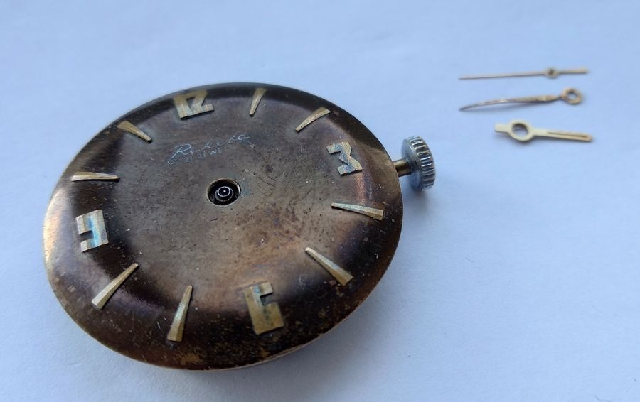 Raketa 2609B movement with all three hands removed, cannon pinion and center seconds pipe visible at the plate surface