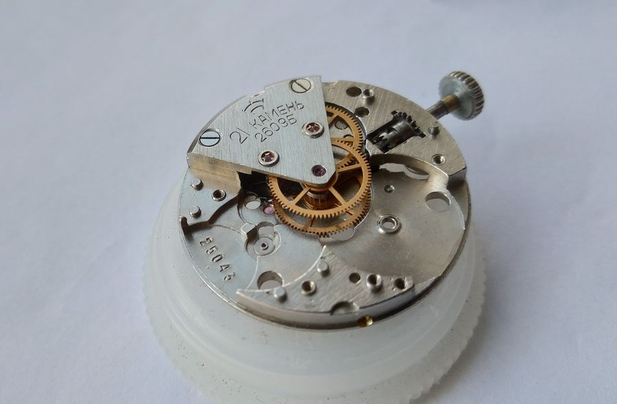 Gear train of the Raketa 2609B reinstalled in the main plate with the sector bridge lowered onto the pivot jewels and screwed down, all wheels confirmed in their jewels
