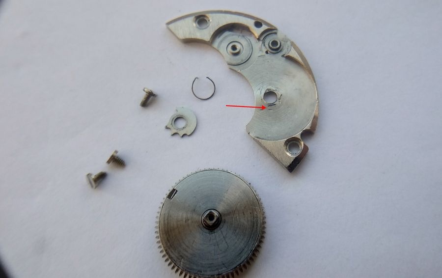 Underside of the Raketa 2609B barrel bridge showing three mounting screws of differing lengths — two short and one long