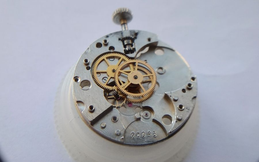 Gear train of the Raketa 2609B fully exposed in the main plate after bridge removal, showing the seconds wheel, intermediate wheel, and escapement wheel in their jeweled positions