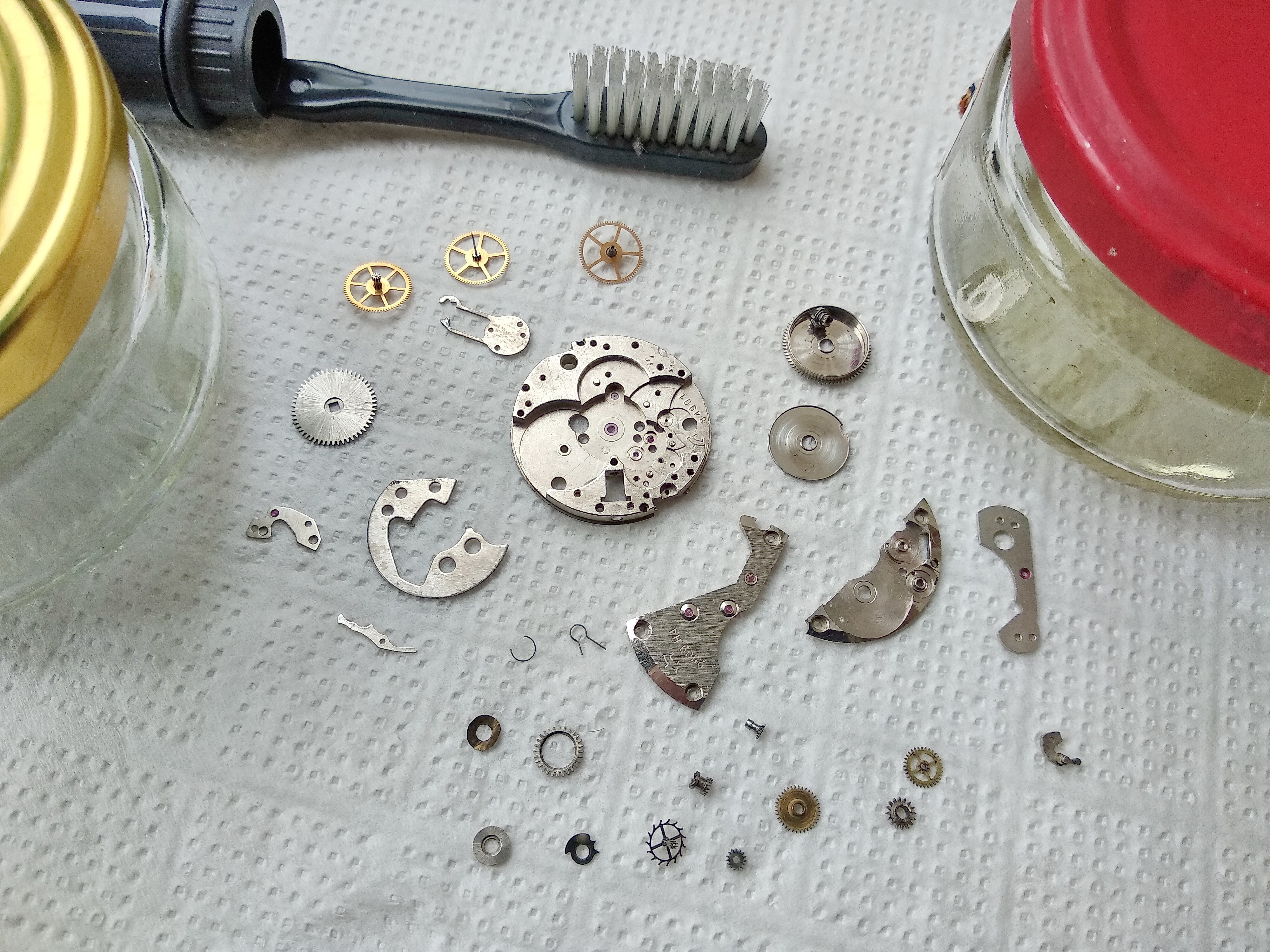 Cleaned movement parts drying on a white napkin