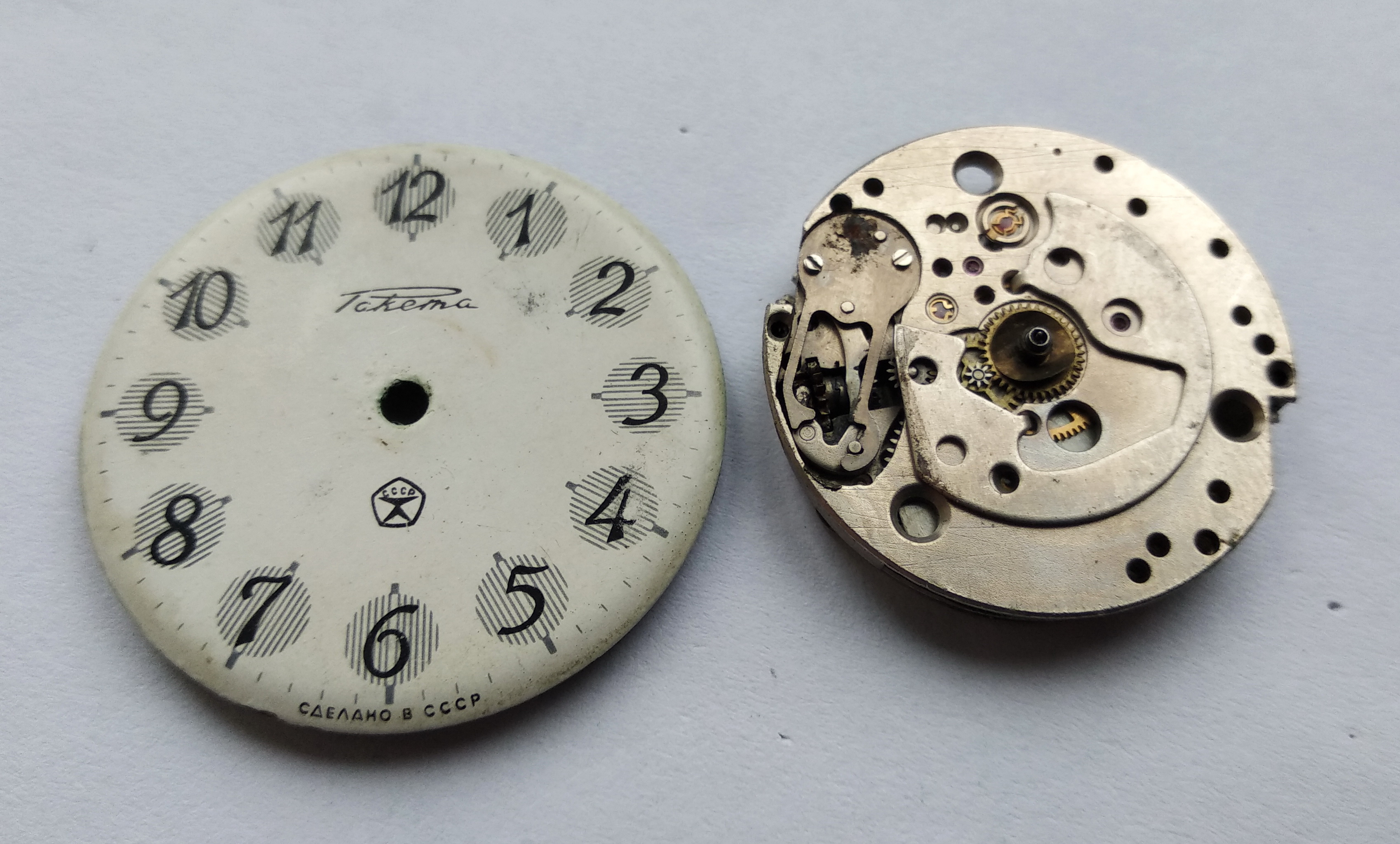 Dial lifted clear of the movement, exposing the motion-works side