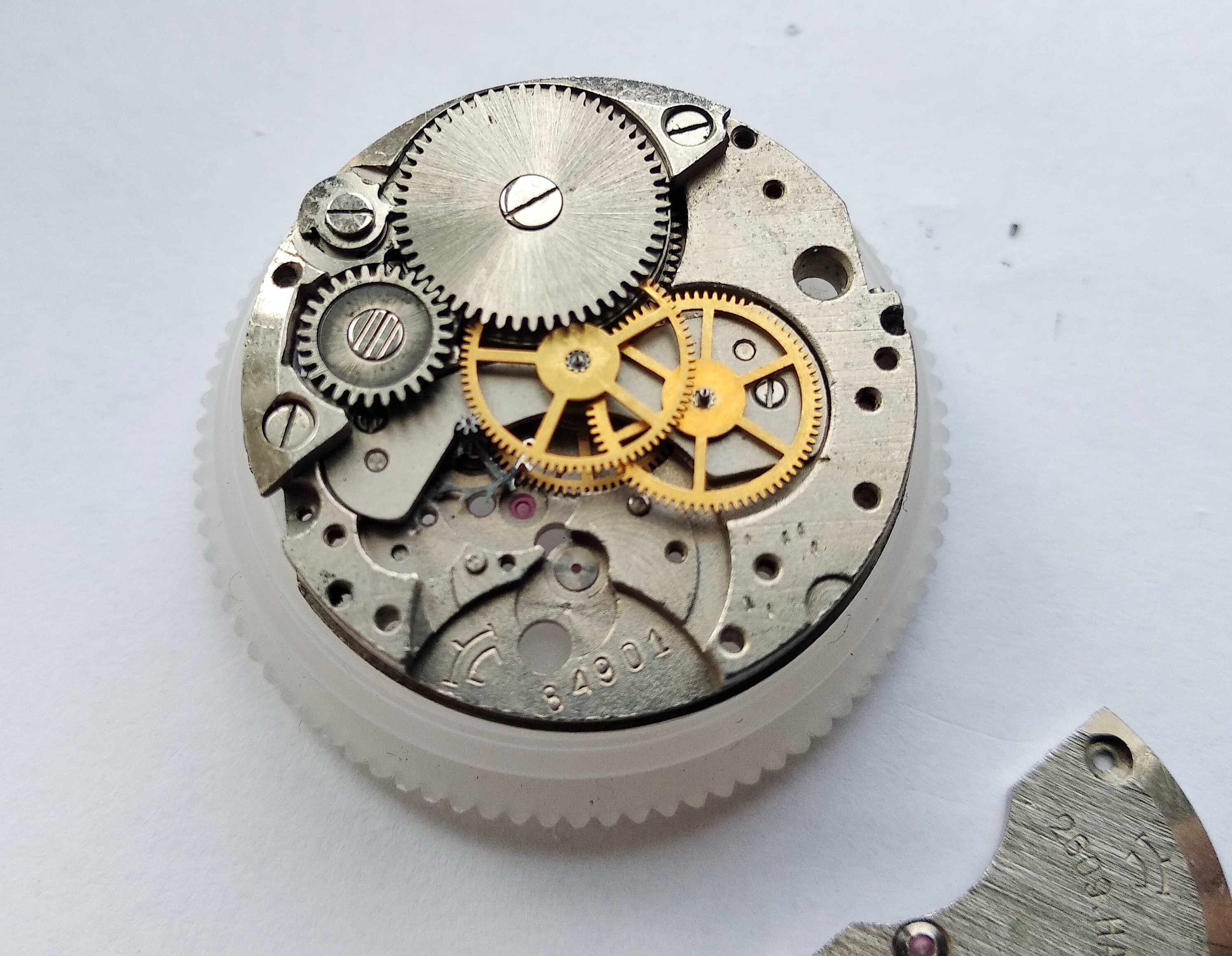 Seconds wheel and intermediate wheel exposed on the main plate after the bridge is removed