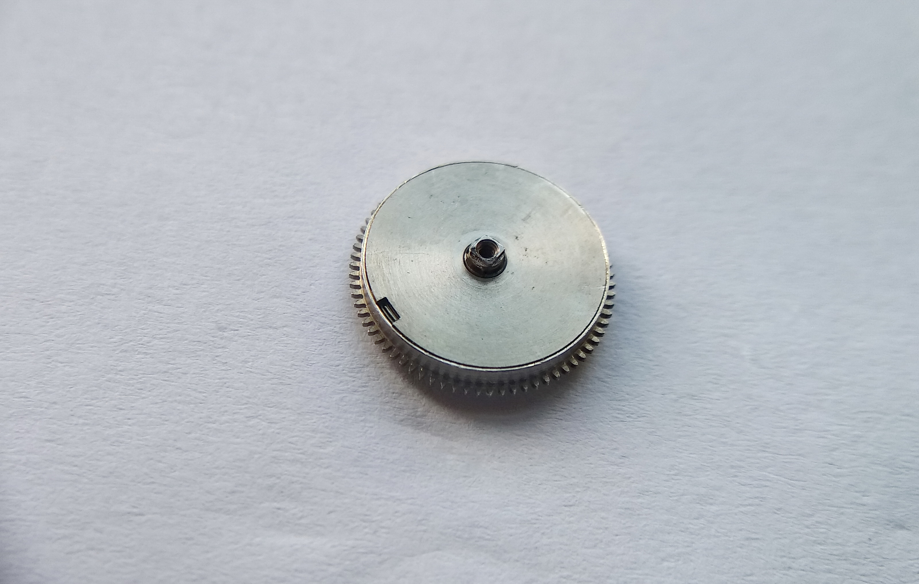Barrel cover being fitted, with its slot aligned to the mainspring bridle