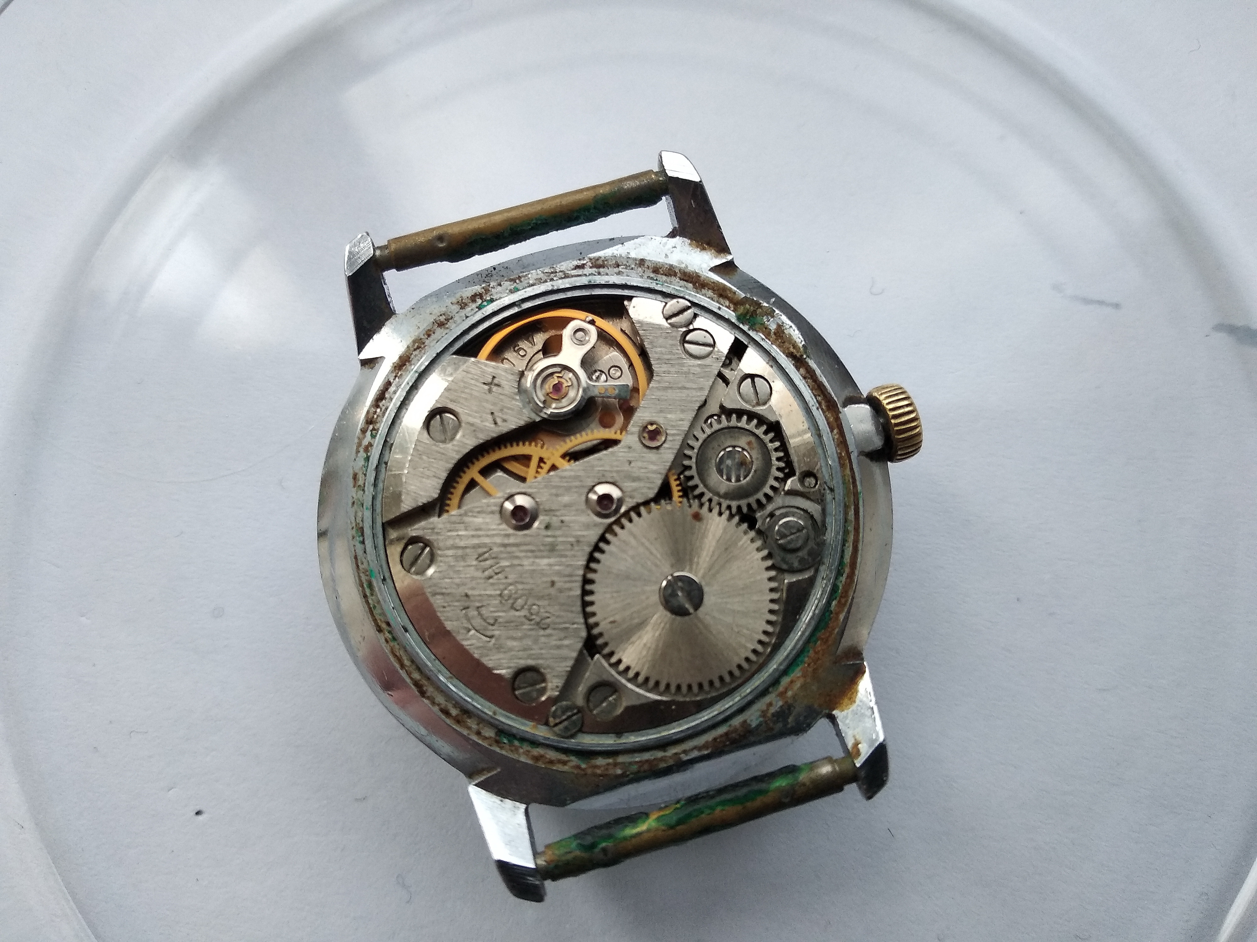 Snap-on caseback levered open to reveal the dial side and movement of the running 2609.NA
