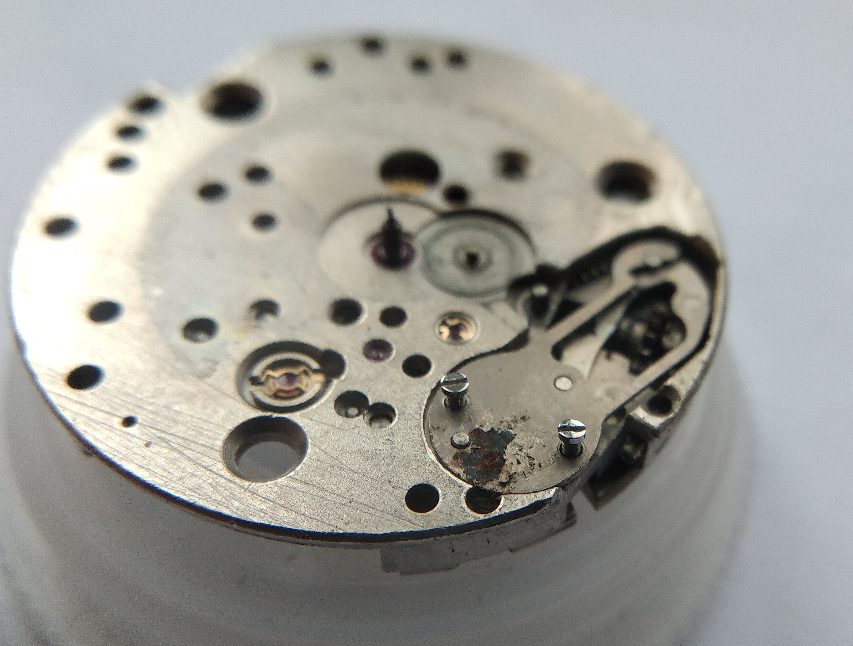 Screws securing the keyless-works cover plate being unscrewed