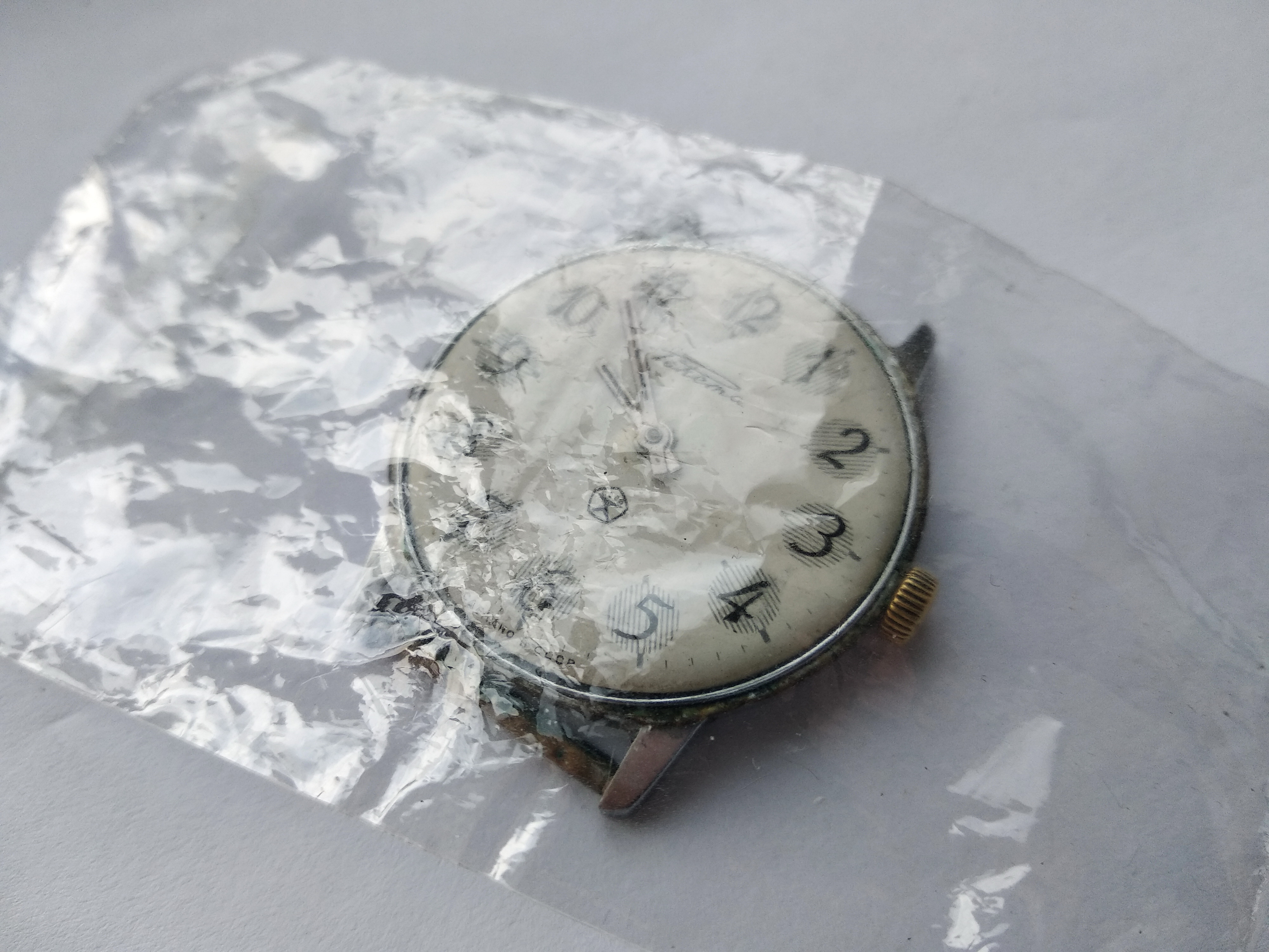 Dial and hands still fitted, dusted with loose dirt before the hands are pulled