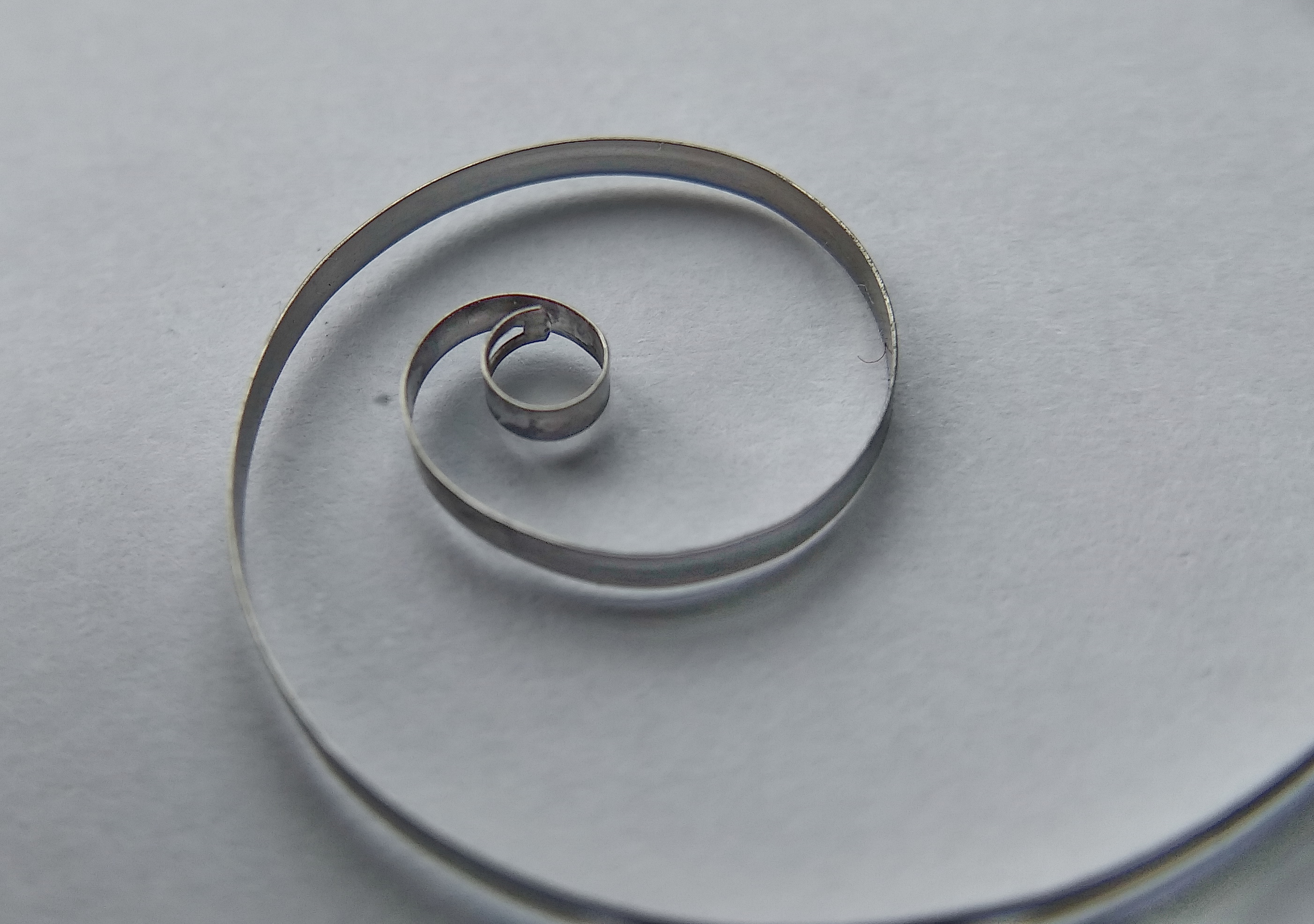 Inner end of the mainspring with the loop that hooks onto the barrel arbor