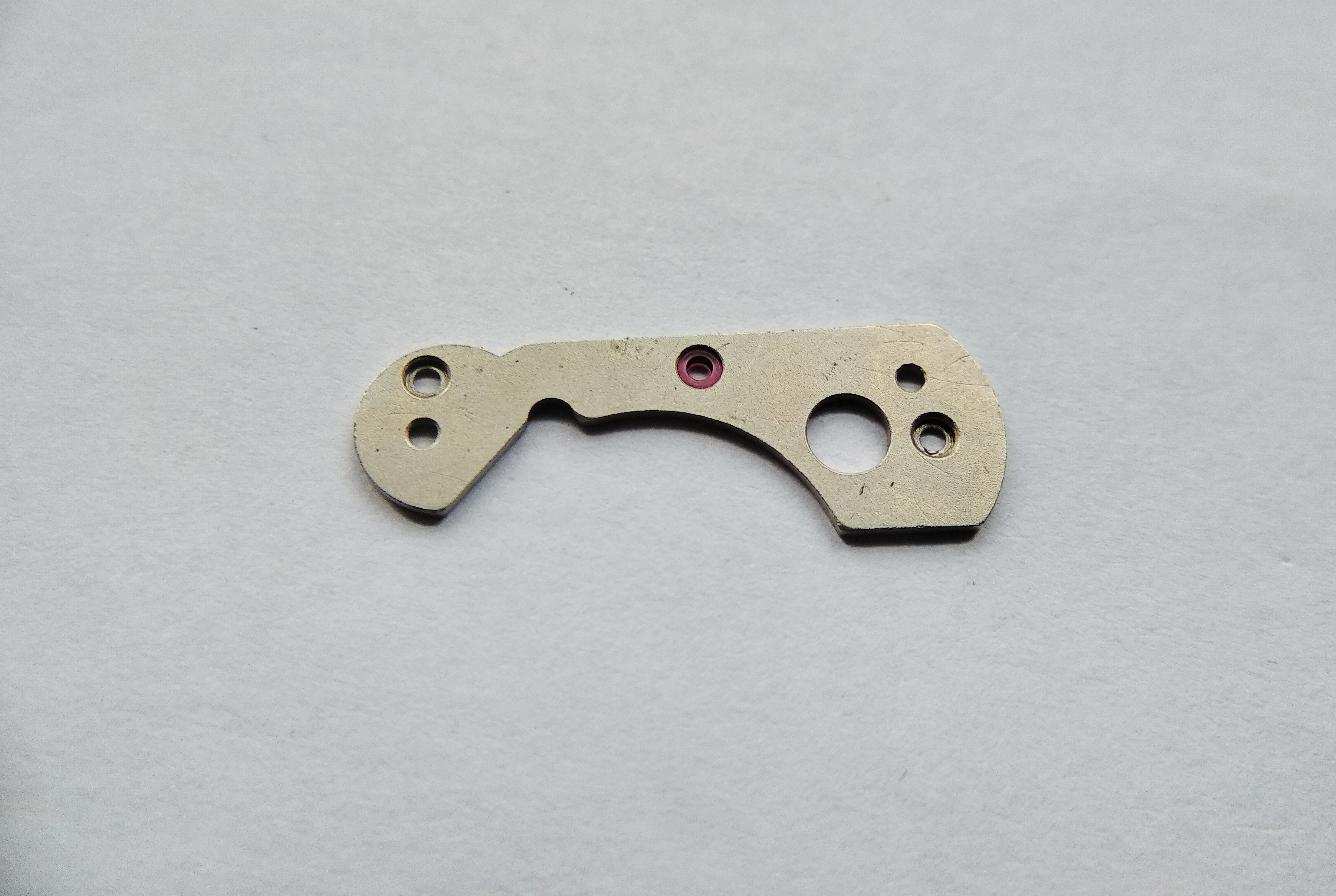 Center wheel bridge detail showing a jeweled bearing and countersunk fixing screws