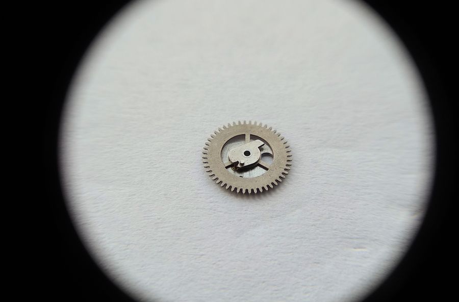 The command wheel from the opposite side showing the jumper tooth and its toothed rim