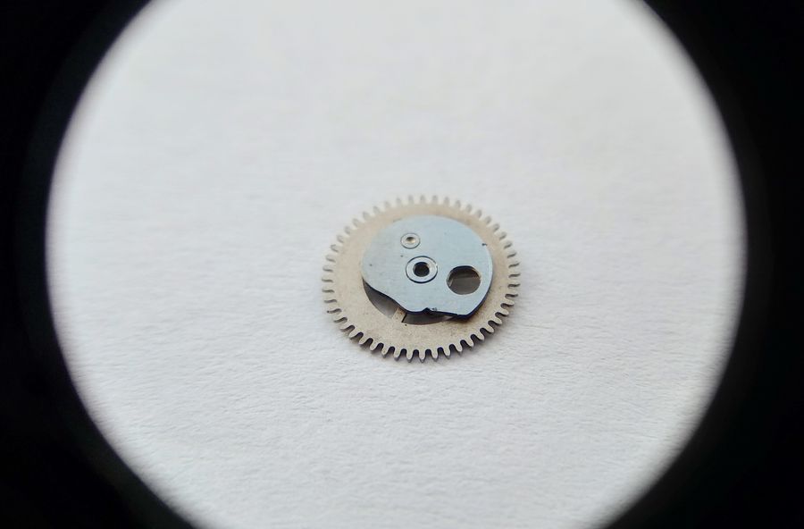 The calendar command wheel shown from the side carrying the shaped cam profile