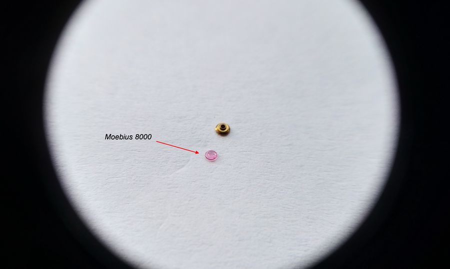 A single drop of oil being placed on the balance cap jewel