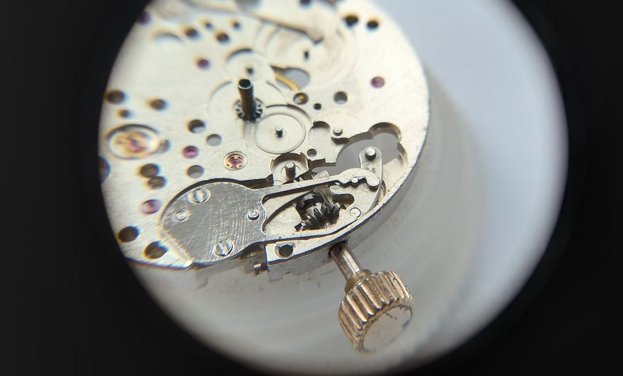 A loupe view of the keyless works with the date-correction lever lifted and the stem drawn outward