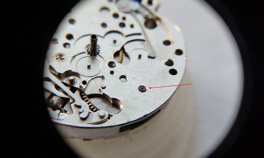 Close view of three small support jewels set in the mainplate where the date disc rides