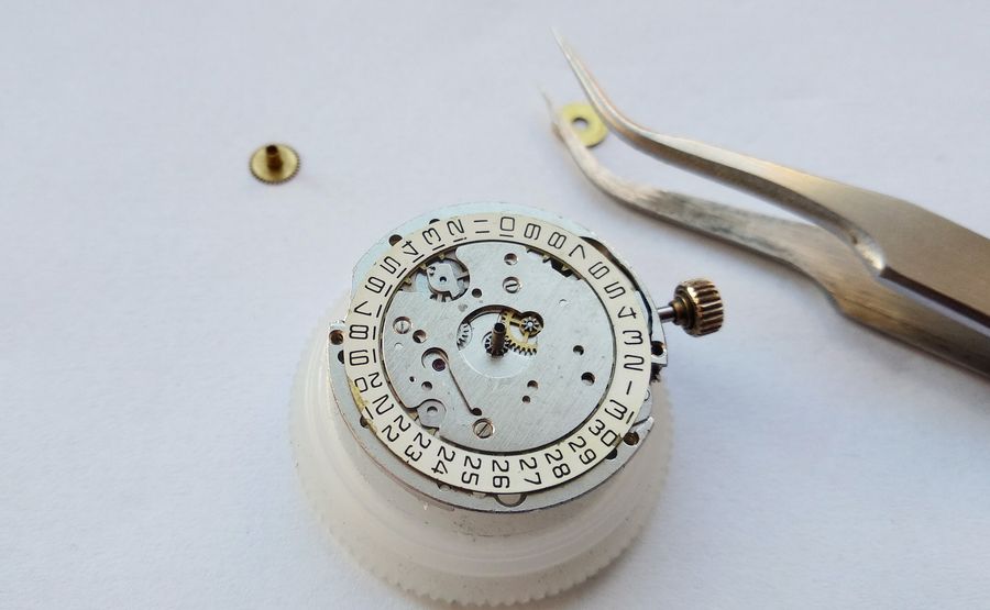 The completed dial-side movement with the calendar assembled, date ring fitted, on a holder