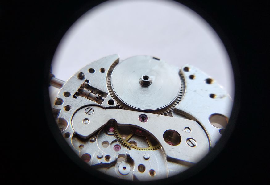 The assembled mainspring barrel being placed onto the mainplate