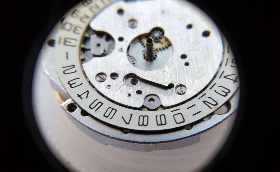 The fitted U-shaped spring, with only its curve showing through the date window aperture