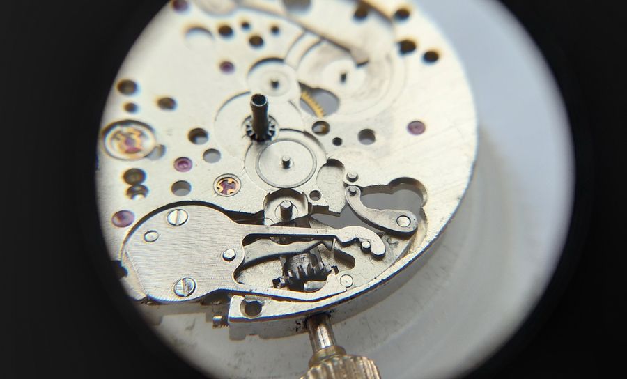 The keyless works on the dial side with the setting levers and the added date-correction lever in place