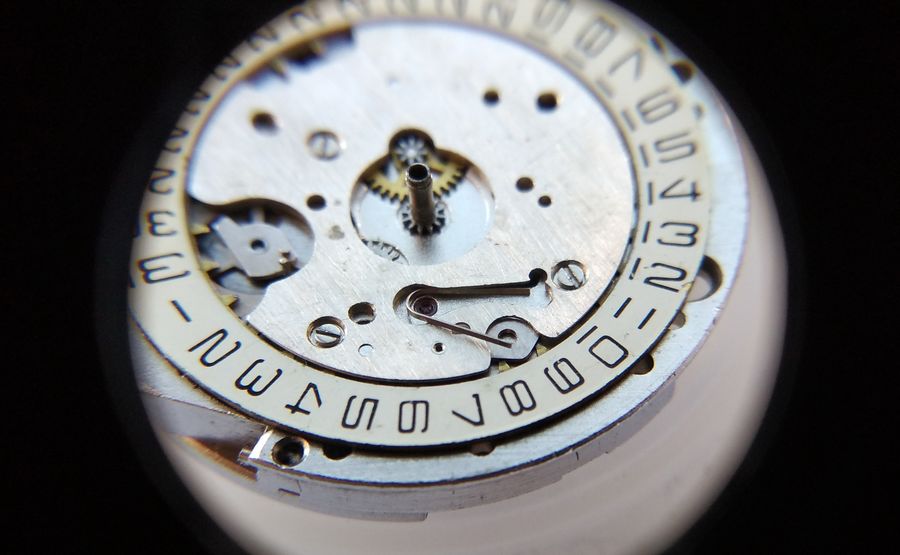 The correct U-shaped calendar spring being placed into its slot in the calendar bridge