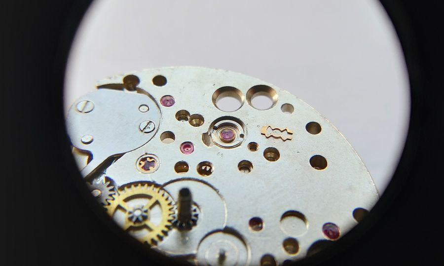 The reassembled cap-jewel setting being placed back into the balance bearing